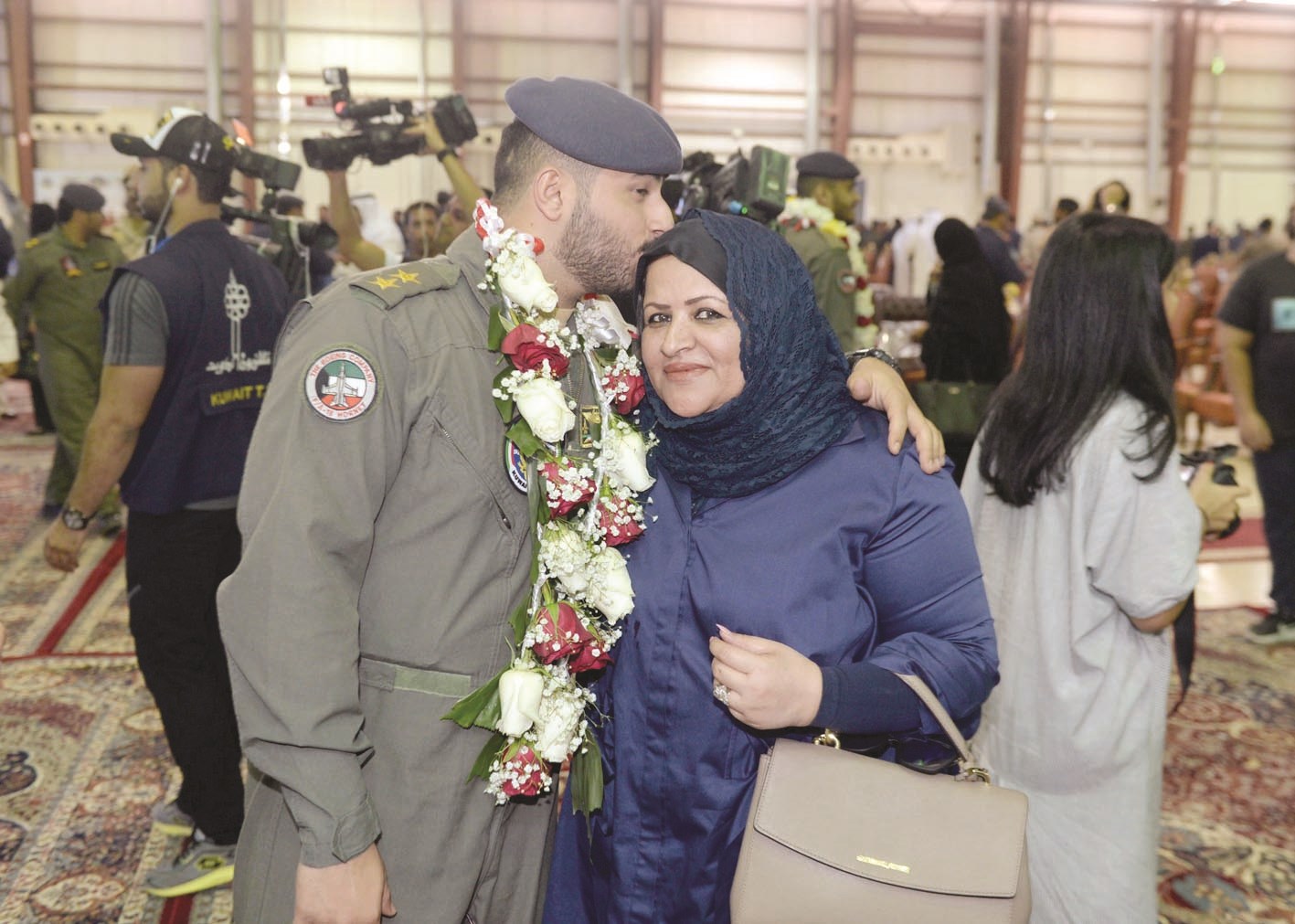 طيار مكلل بالورد يقبل رأس والدته