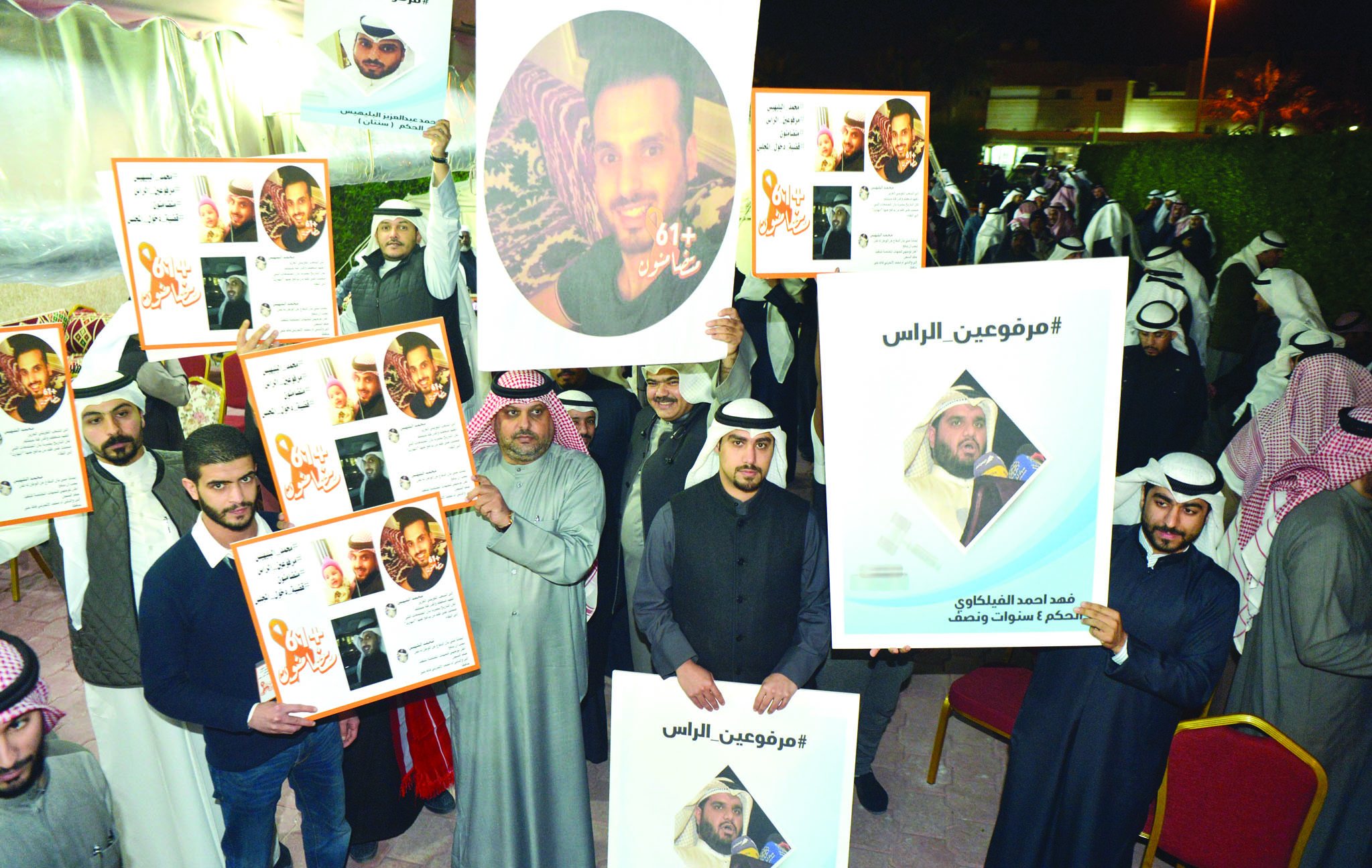 الحضور يرفعون صورا للمسجونين