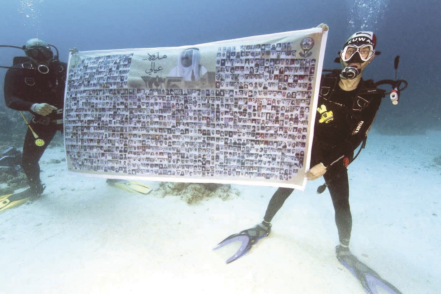 محمد البحراوي حاملاً جدارية مكتب الشهيد تحت الماء