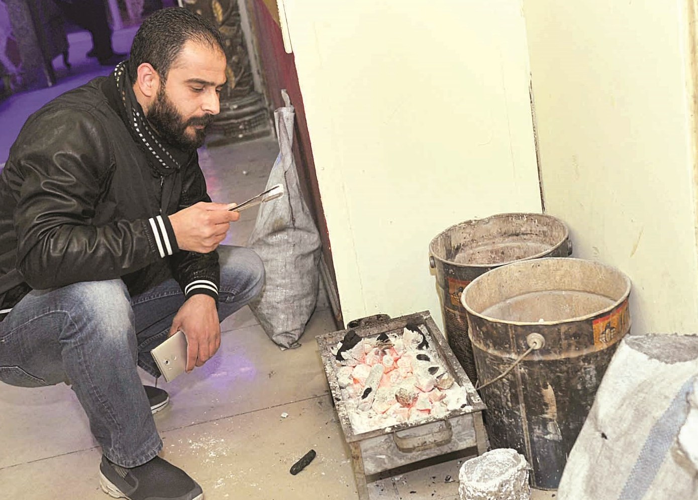 الزميل محمد أنور يعاين الجمر الخاص بالشيشة