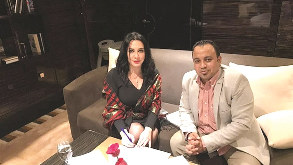 سلاف مع المنتج أحمد رزق خلال توقيع عقد «روح»