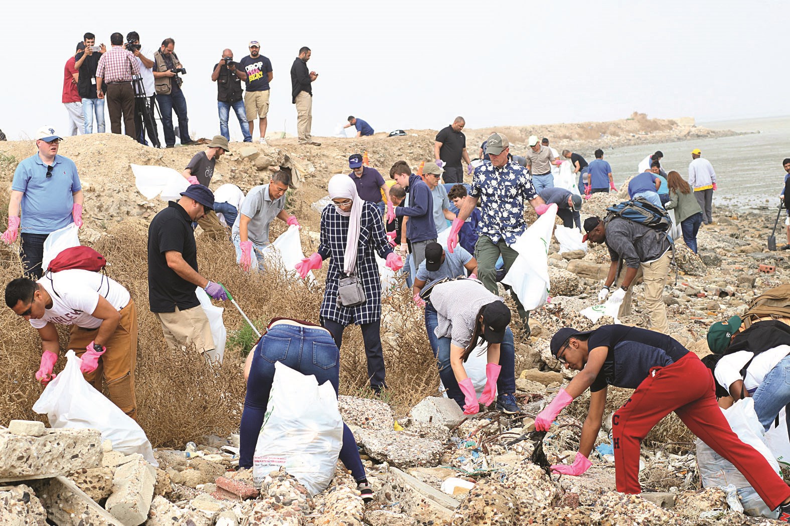 متطوعون منهمكون في تنظيف الشاطئ