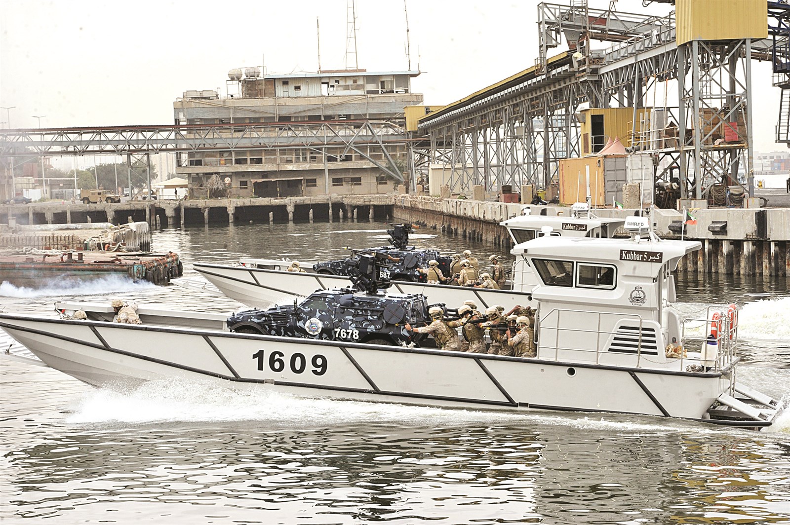 زورق يحمل القوات العسكرية مع سيارات الدعم