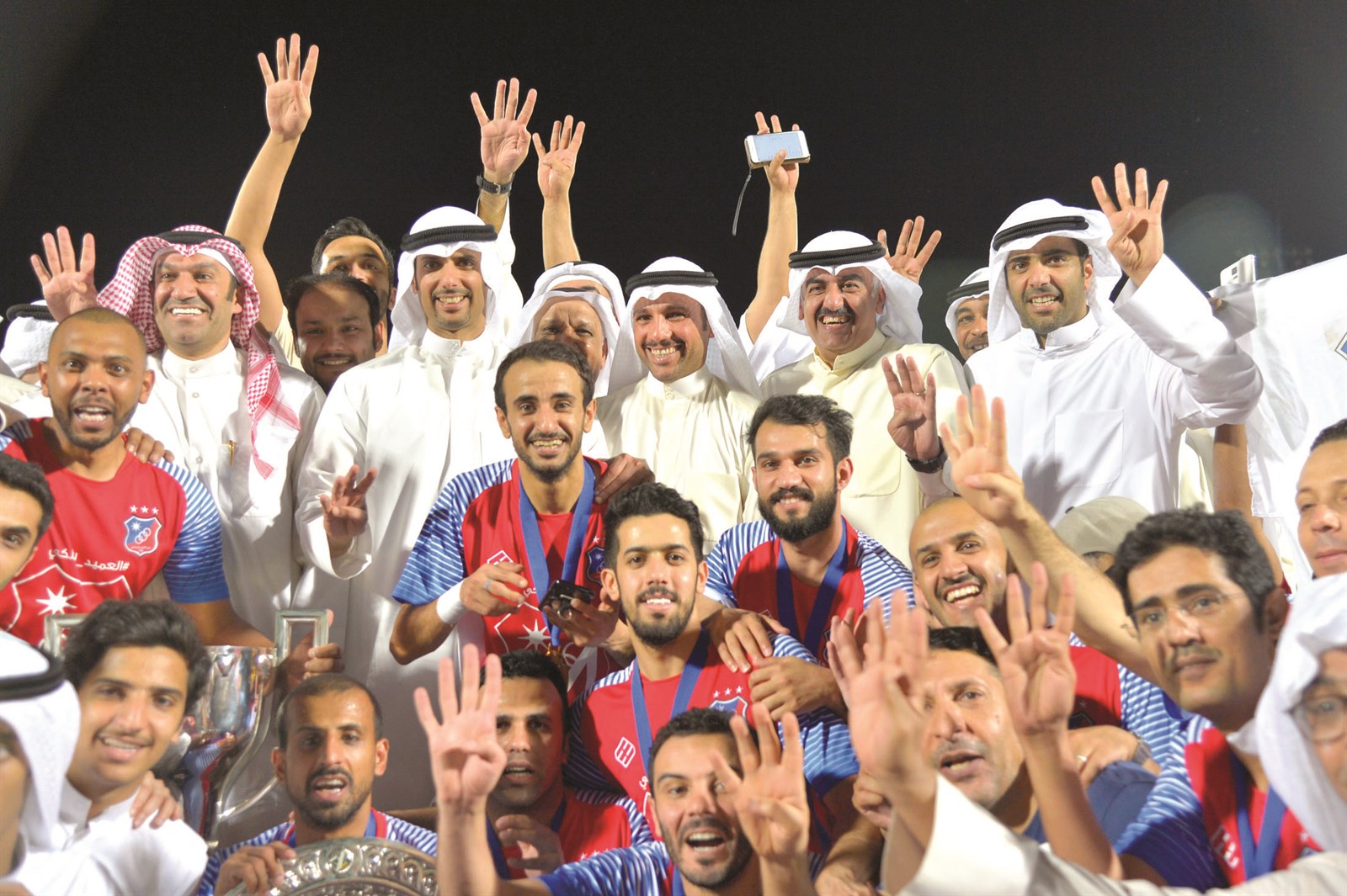 الرئيس الفخري لنادي الكويت مرزوق الغانم يتوسط أعضاء مجلس الإدارة واللاعبين بعد التتويج