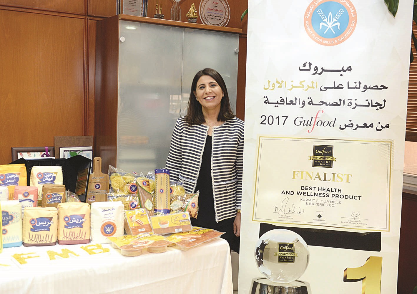 الحميضي بين لوحة تهنئة بجائزة دبي وعدد من منتجات الشركة (تصوير زكريا عطية)