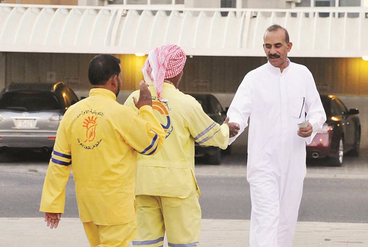 مصلٍ يوزع النقود على العمال