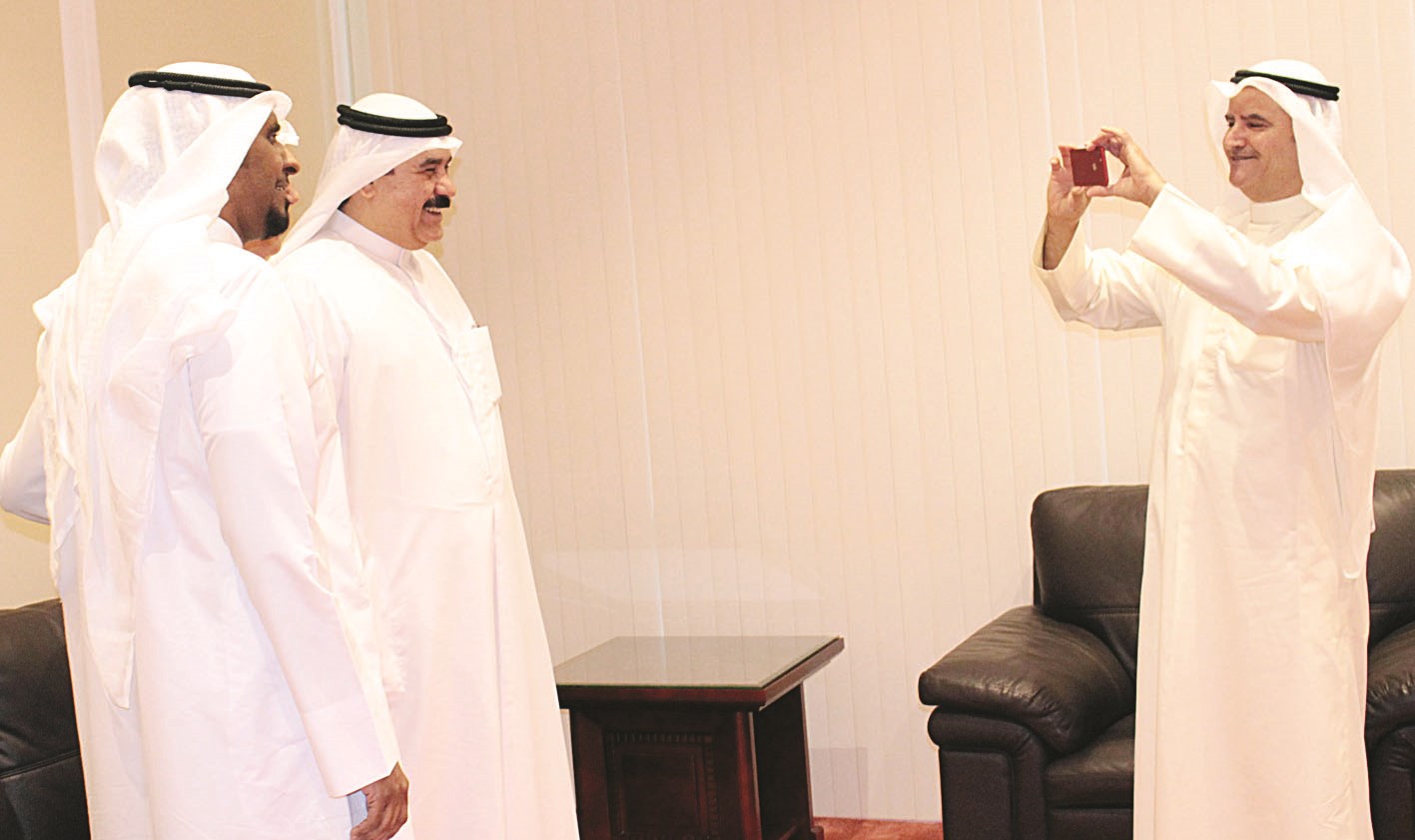 المرزوق يلتقط صورة للوكيل المساعد السابق حامد الخالدي وأحد موظفي الوزارة