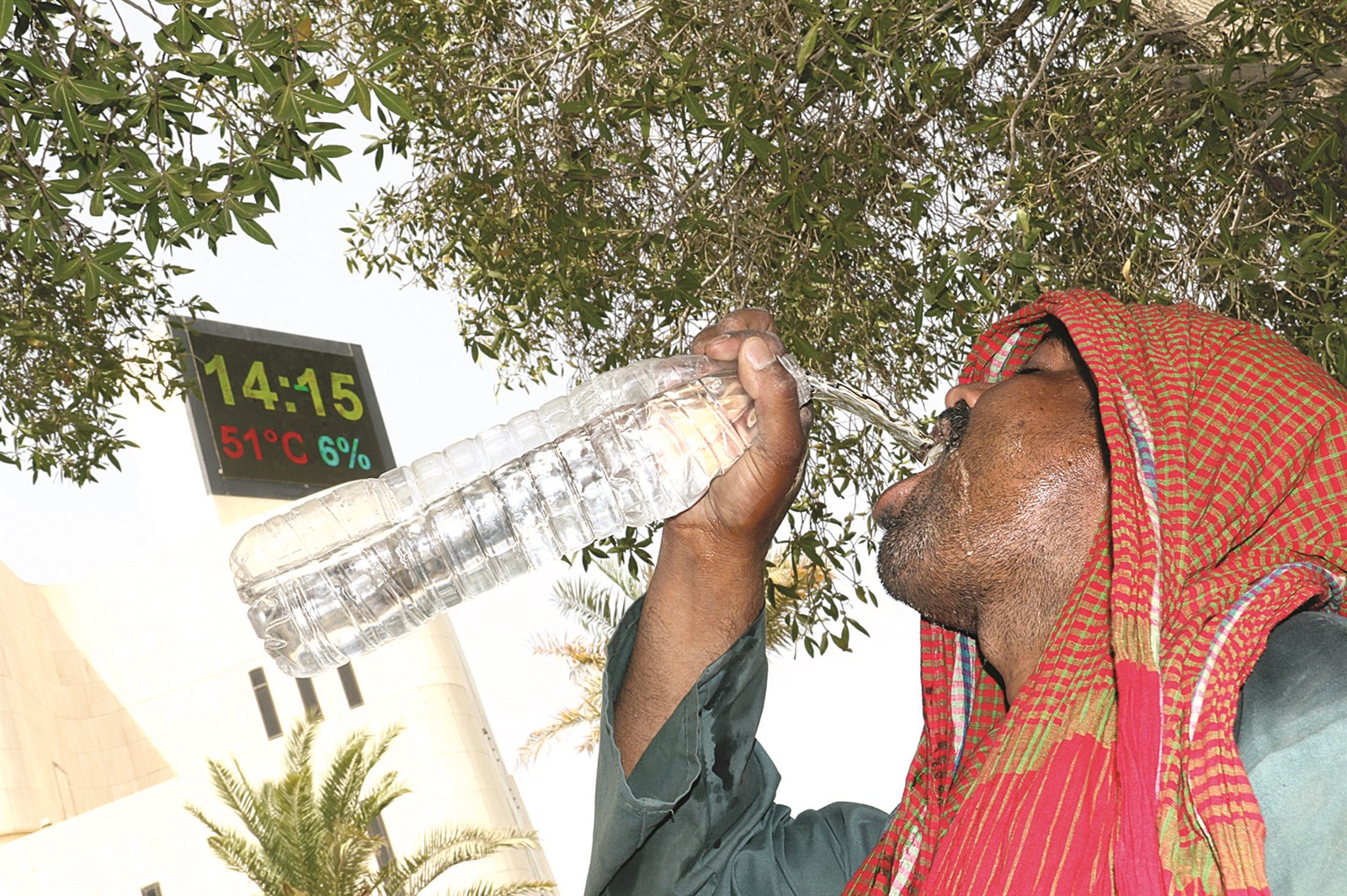 عامل يروي عطشه في ظل حرارة وصلت إلى 51 درحة مئوية (تصوير أسعد عبدالله)