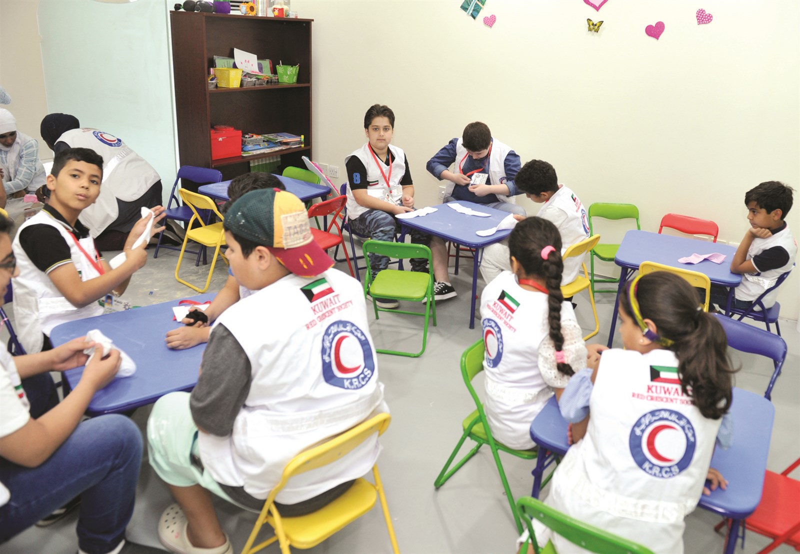 أطفال يستمعون لشرح حول العمل التطوعي