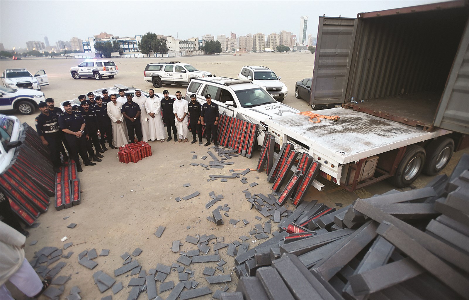 رجال الأمن أمام «الكونتينر» بعد الكشف عن الخمور المخبأة ضمن حمولة المواد الإنشائية (تصوير أسعد عبدالله)