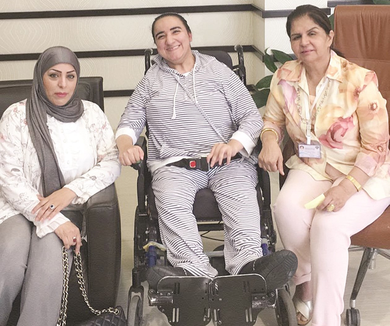 العوضي مع عبير العجمي بعد تسليمها الكرسي المتحرك