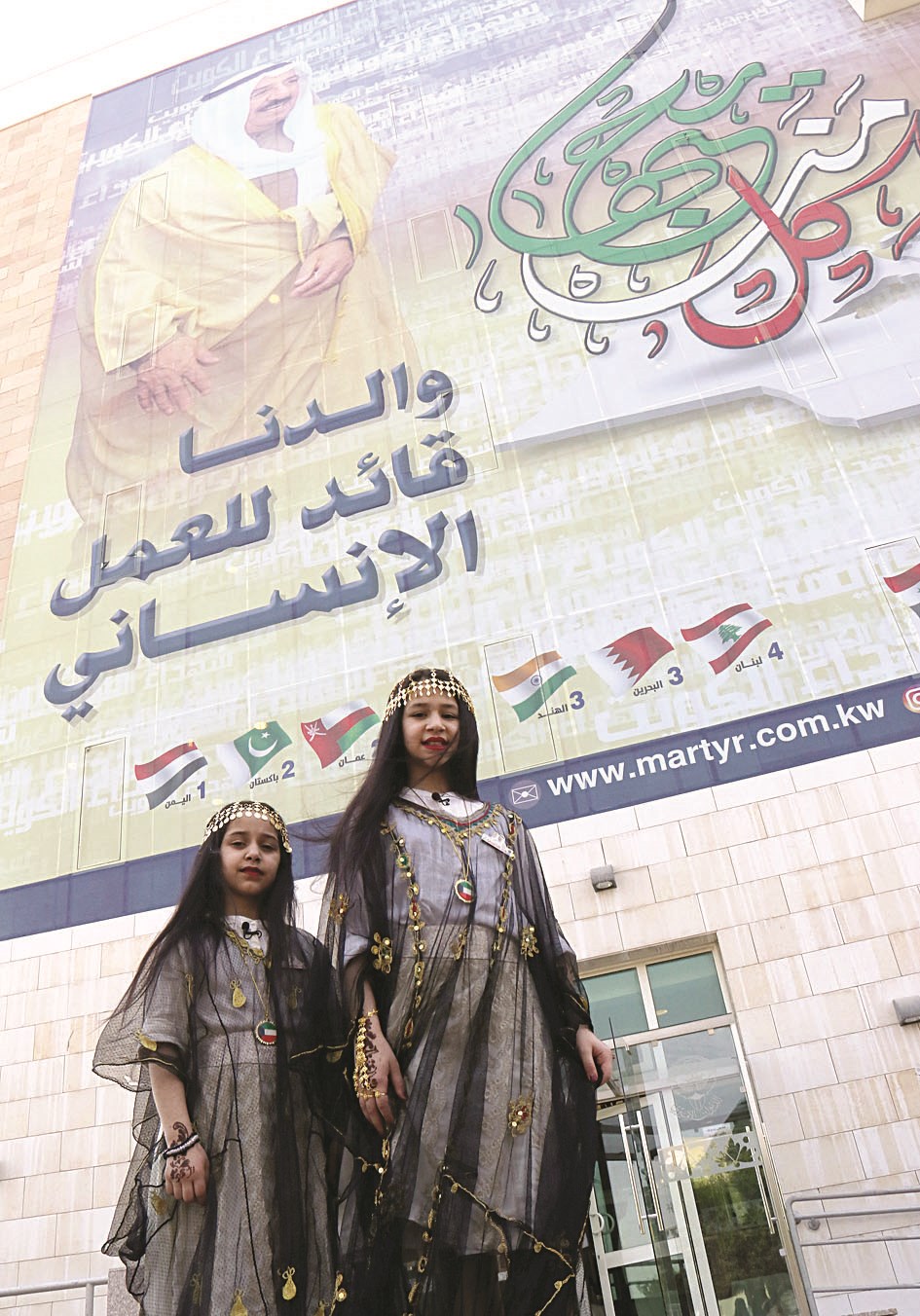 طفلتان من أبناء الشهداء أمام الجدارية