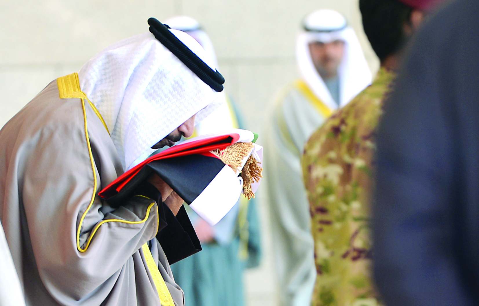 جابر المبارك يقبل العلم قبل رفعه 		(تصوير أسعد عبدالله ونايف العقلة)