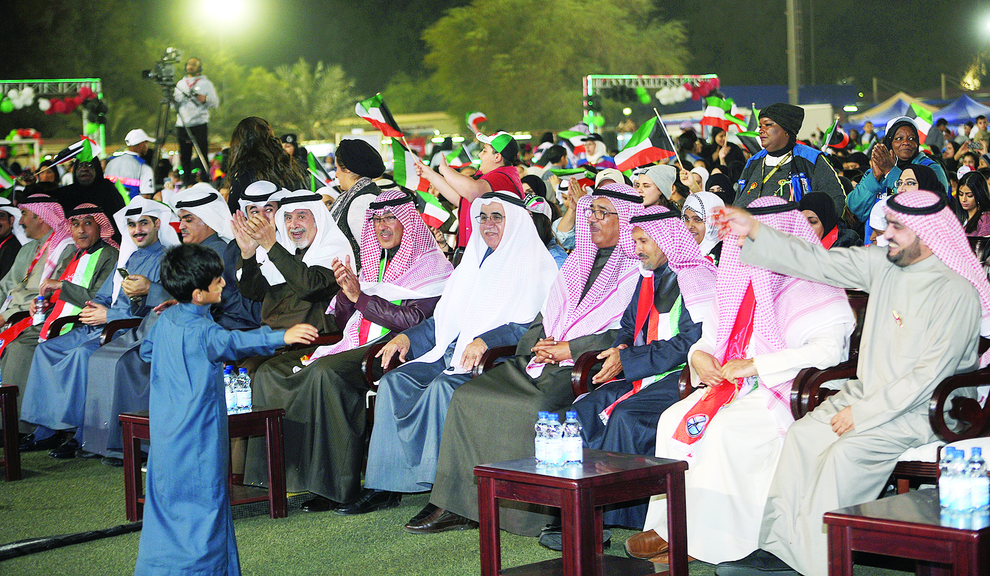 فواز الخالد وكبار الحضور يتابعون طفلاً يؤدي عرضاً احتفالياً   	       (تصوير كرم ذياب)