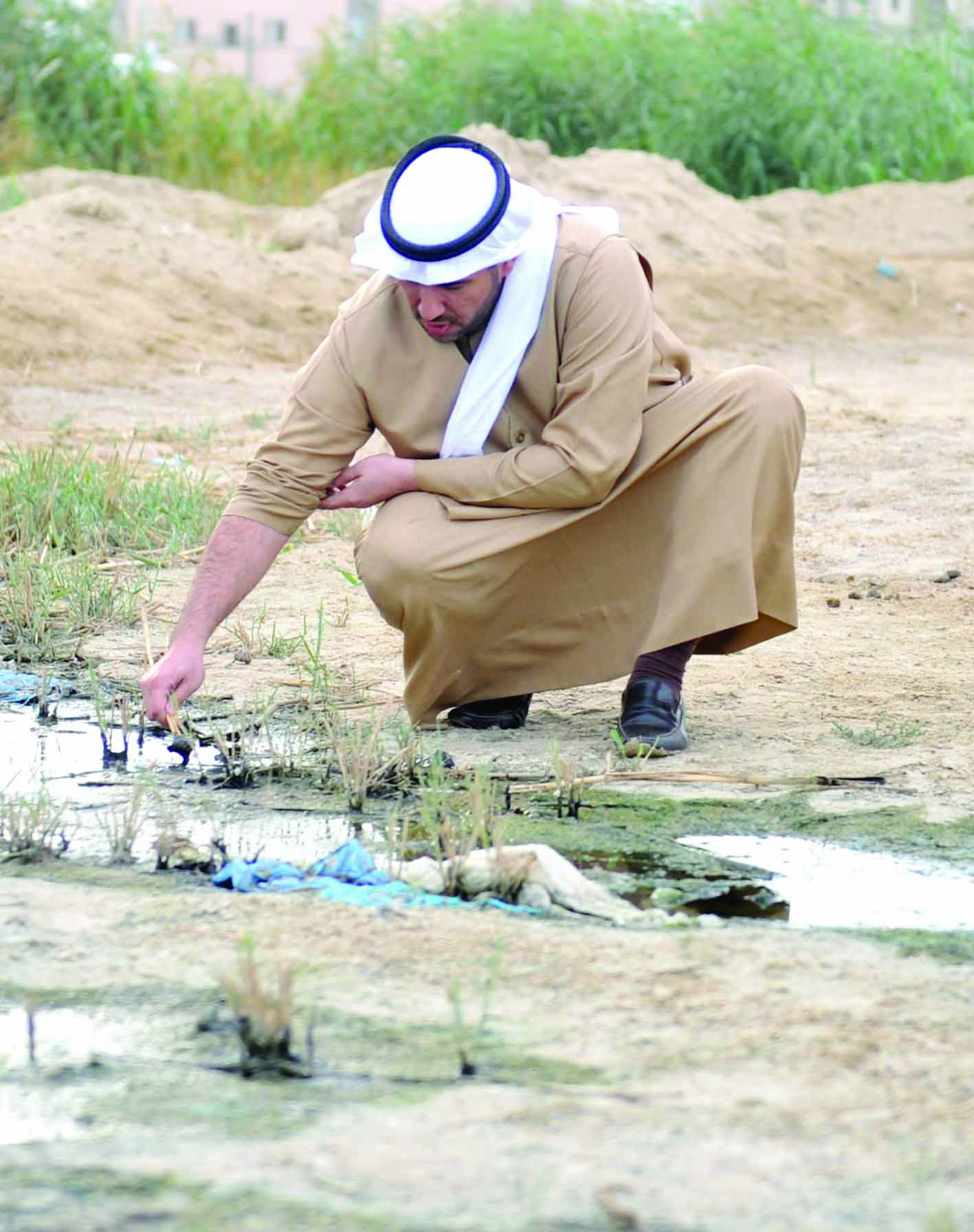 عبدالله الأحمد يدقق في مياه مجرى سطحي