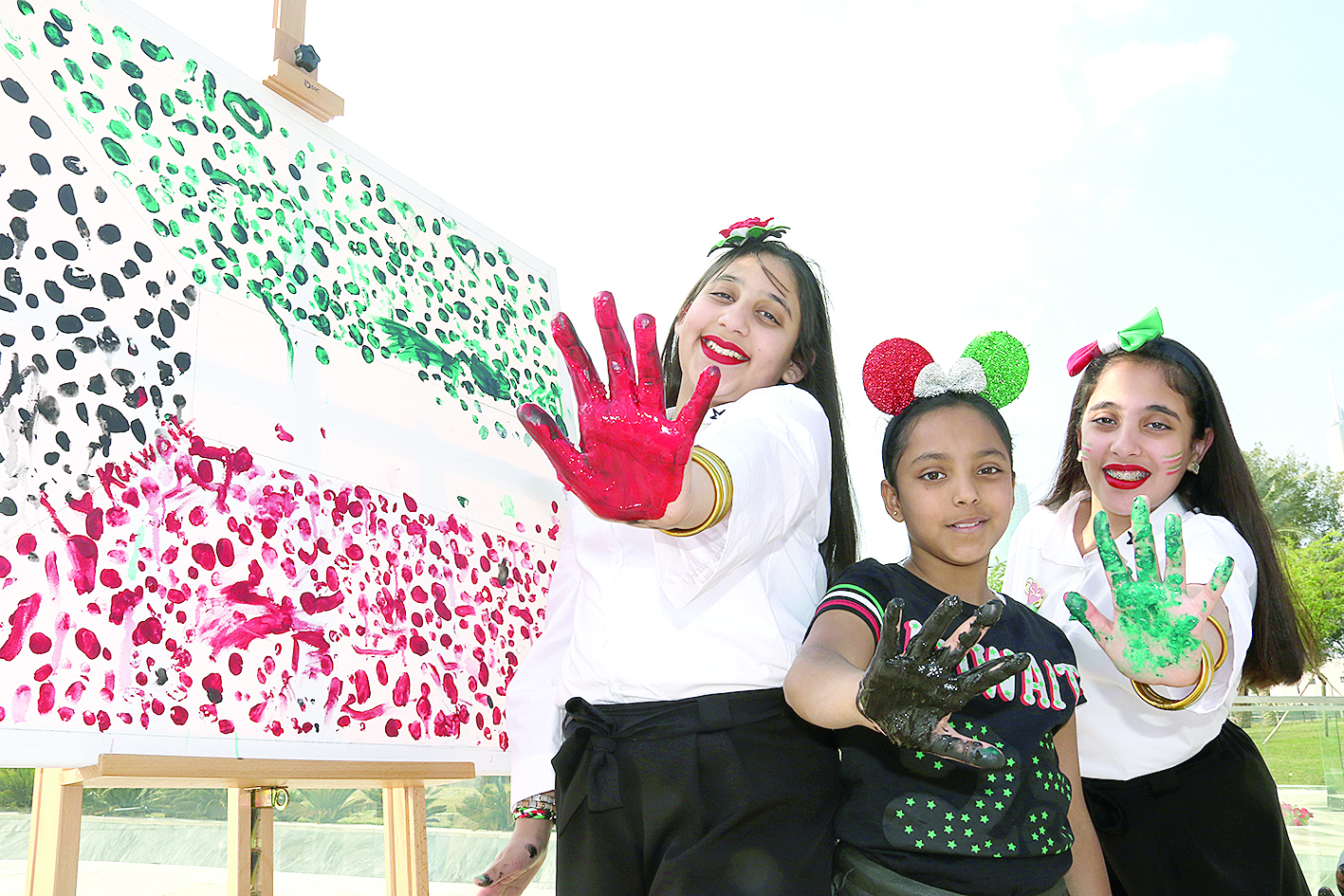 أطفال يلونون جدارية بألوان العلم