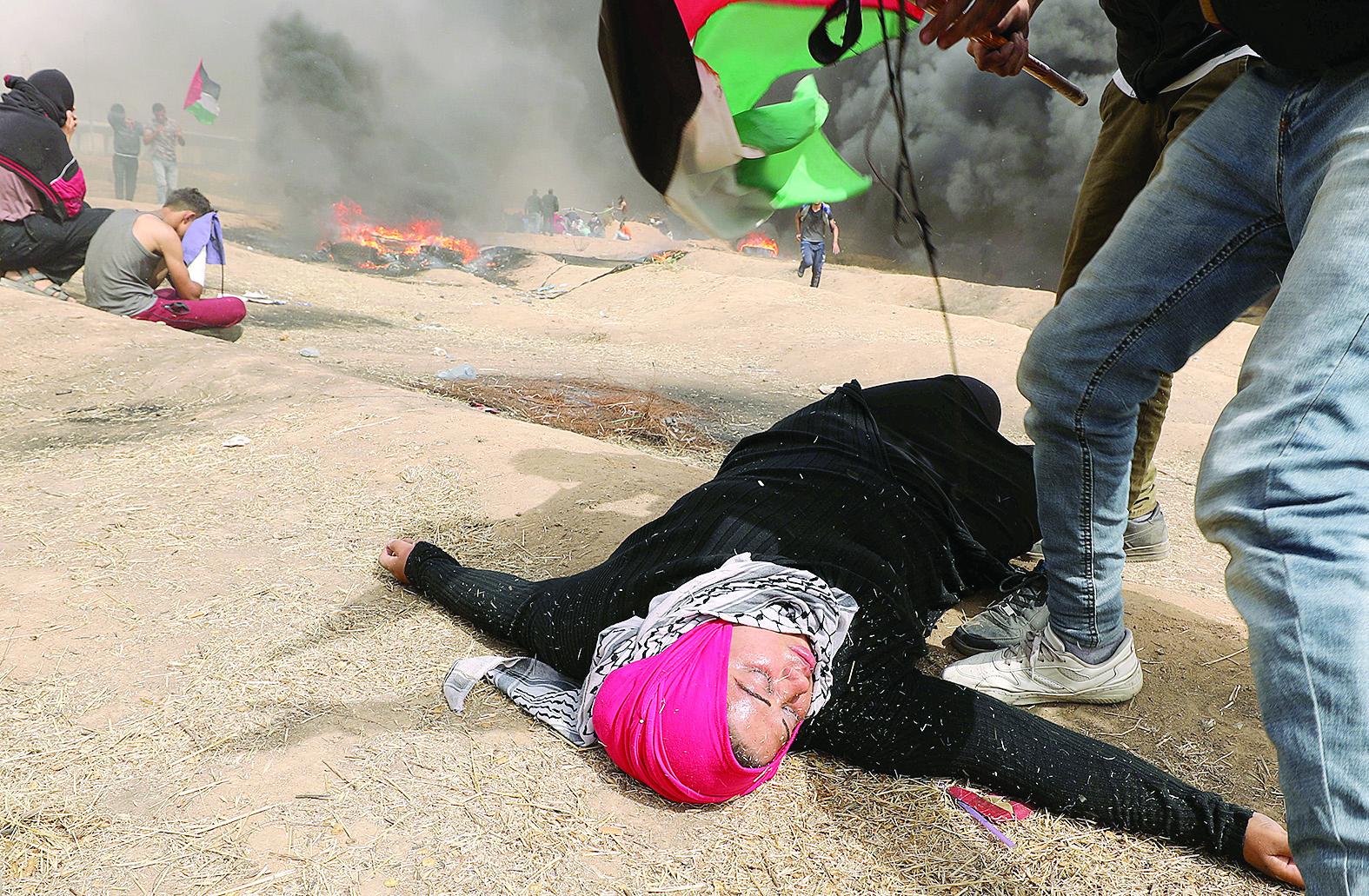 فلسطينية مشاركة في «مسيرة العودة» أصيبت بالإغماء بعد استنشاق الغاز المسيل للدموع 	(رويترز) 