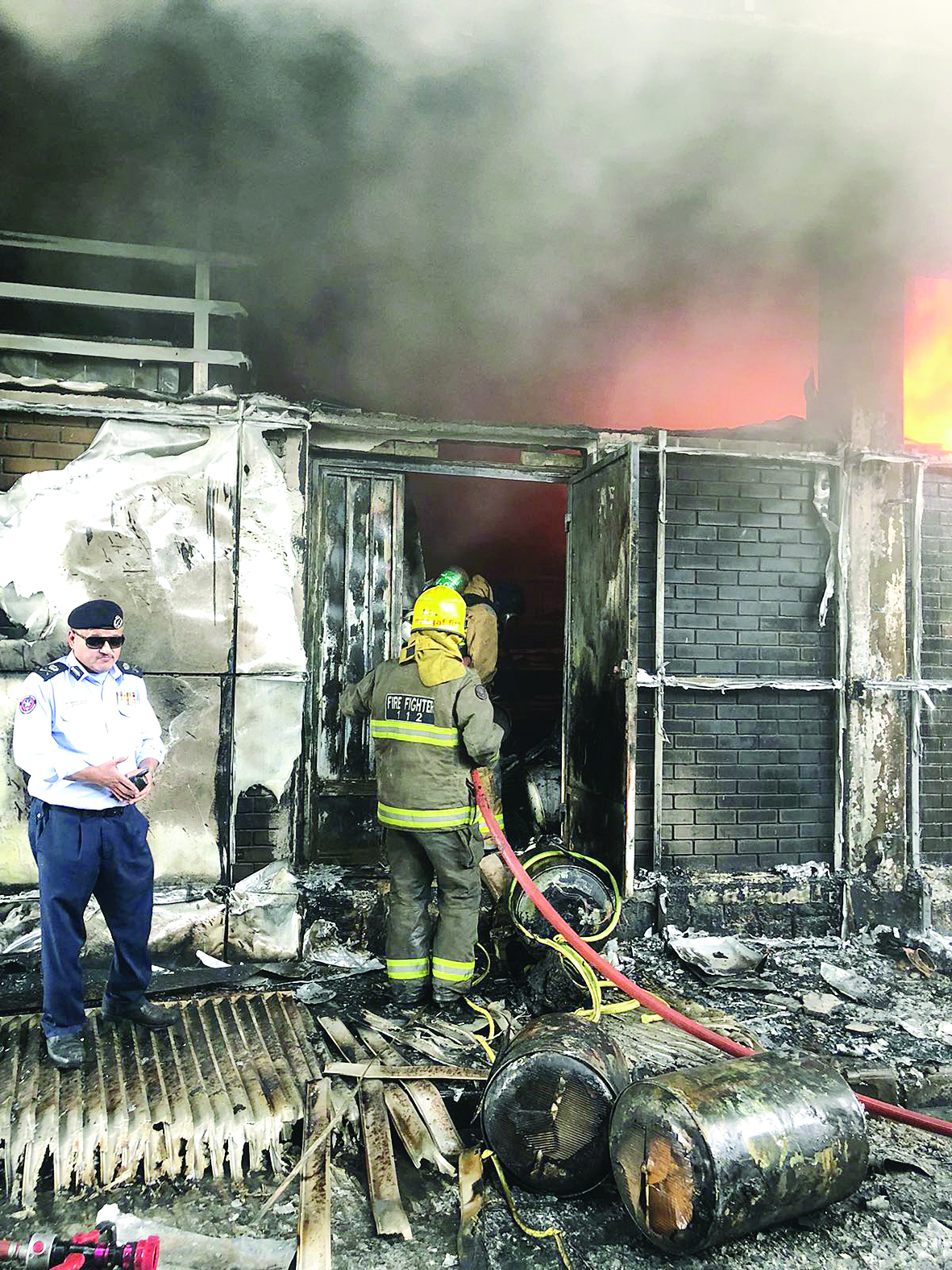 إطفائيون يكافحون النيران ويبدو اللواء جمال البليهيص