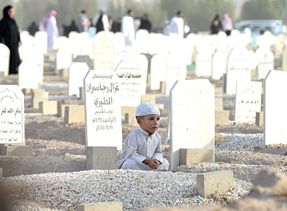طفل في زيارة لقبر أحد الأحبة 