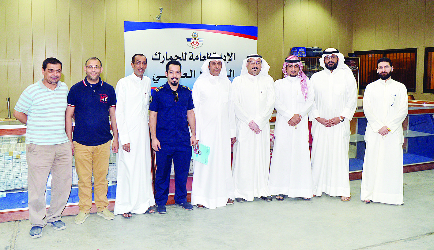 العنزي والزميل ناصر الفرحان يتوسطان فريق لجنة المزاد العلني