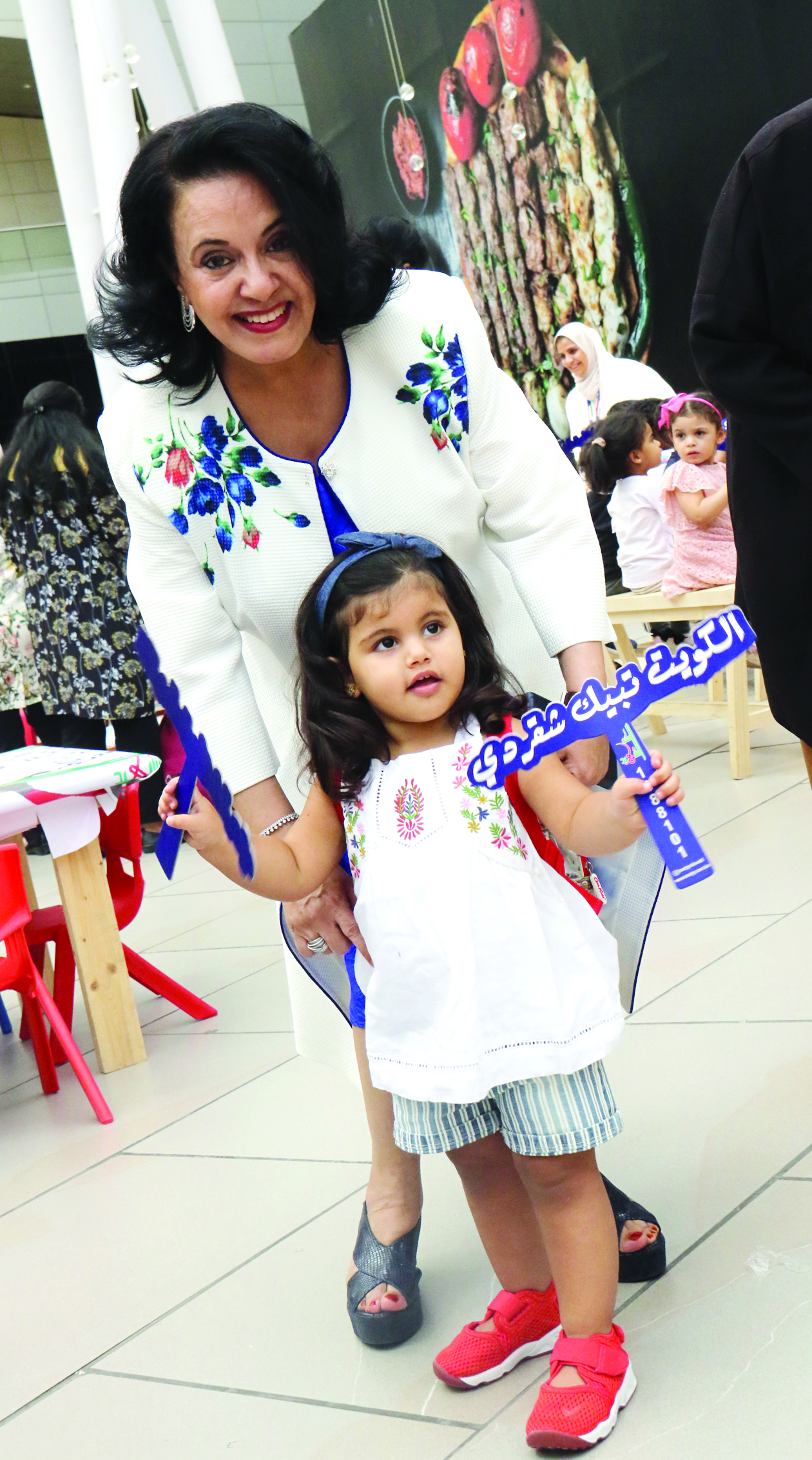 فاطمة الأمير مع طفلة في المعرض