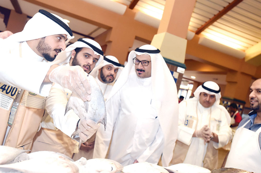 مفتش يفحص سمكة زبيدي      	  	 (تصوير أسعد عبدالله)