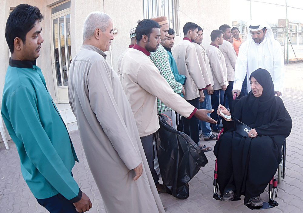 سيدة توزع عيادي على مرتادي أحد المساجد للصلاة 	(تصوير أسعد عبدالله)