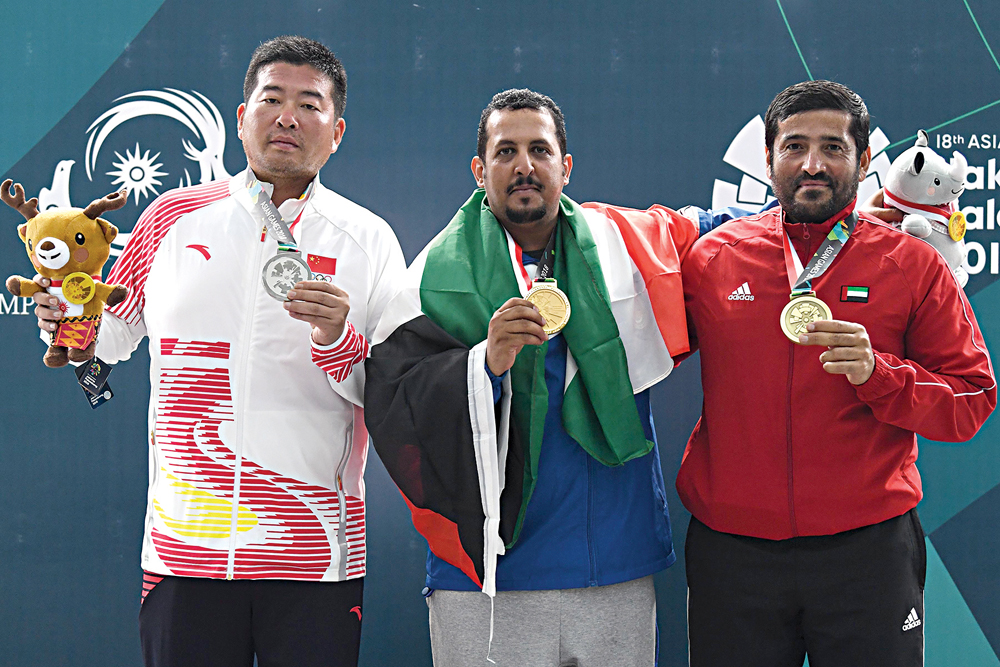 «الذهبي» منصور الرشيدي متوسطاً دي جين وسيف المنصوري 	                  (أ ف ب)