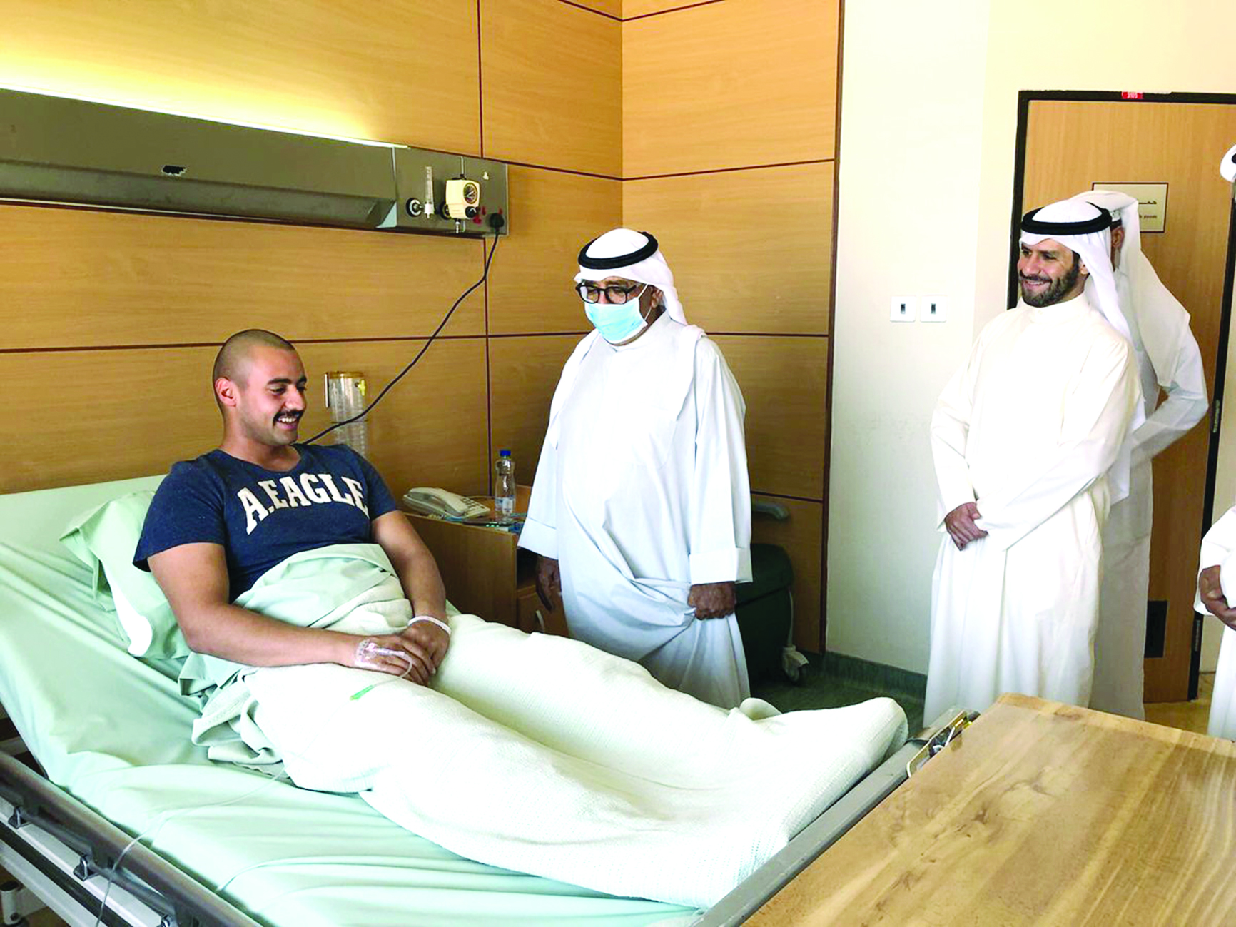ناصر الصباح خلال عيادته أحد الطلاب الضباط المصابين