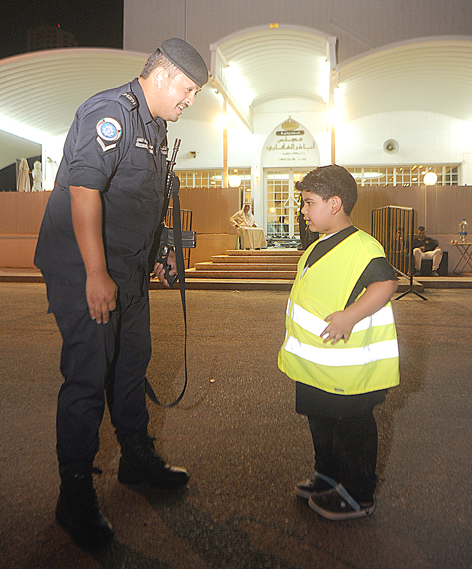 رجل أمن وأحد الأطفال على مدخل الحسينية