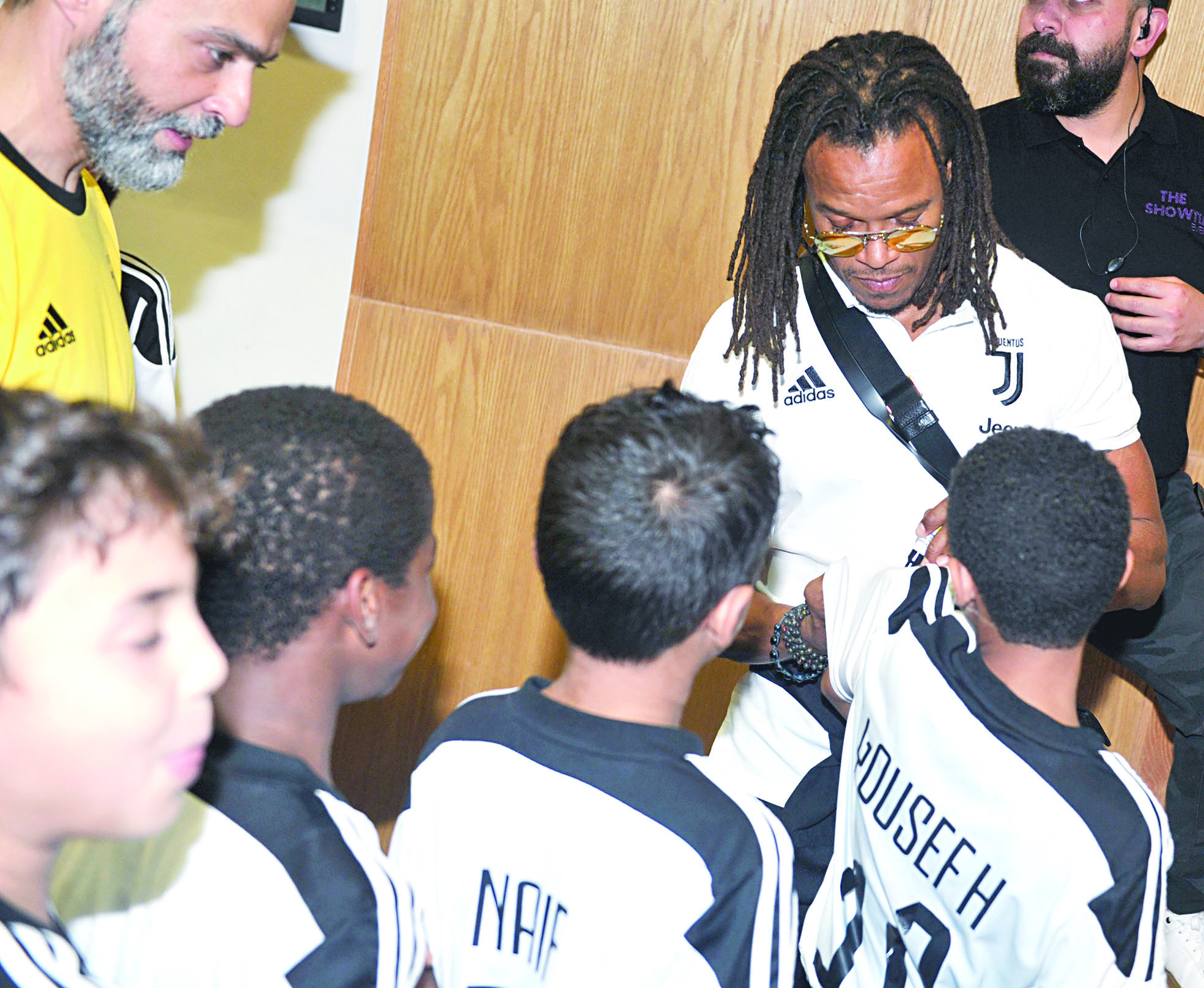 دافيدز يوقّع على قمصان اللاعبين الأطفال عقب المؤتمر	 (تصوير: سعد هنداوي)