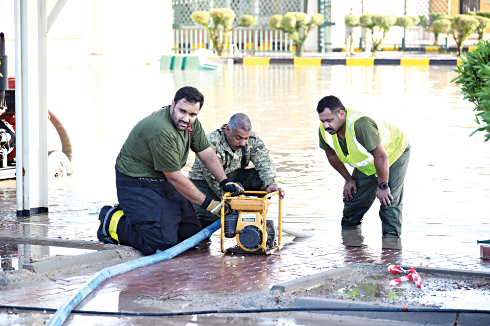 عناصر يسحبون المياه المتجمعة