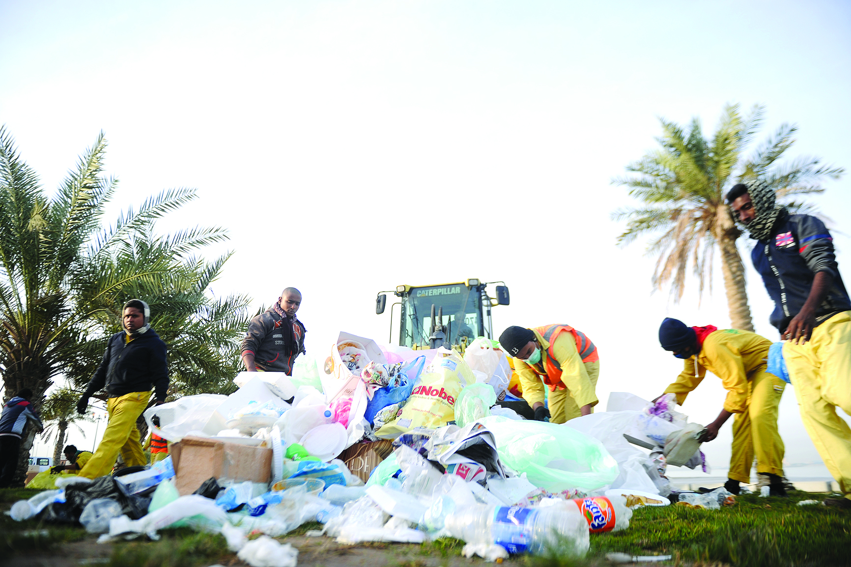 العمال يجمعون المخلفات في أكياس 