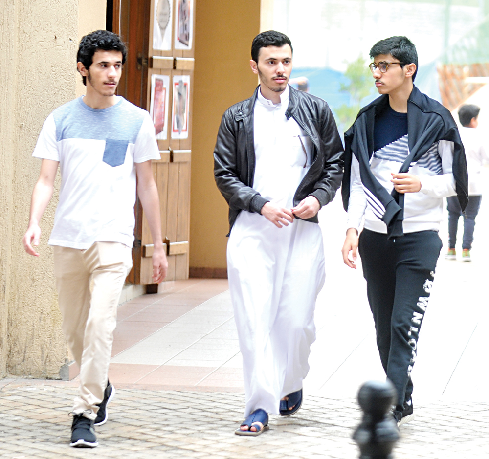 تنوع لباس الشباب بين الدشداشة والـ«سبورت»                   	    (تصوير سعد هنداوي)