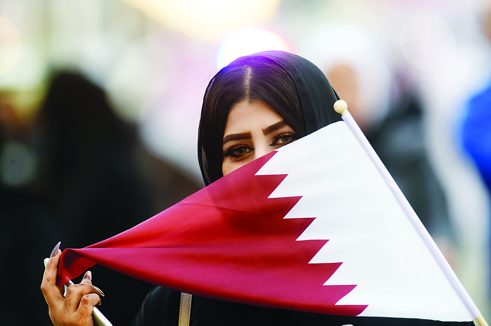 مشاركة في الاحتفالات تحمل علم قطر