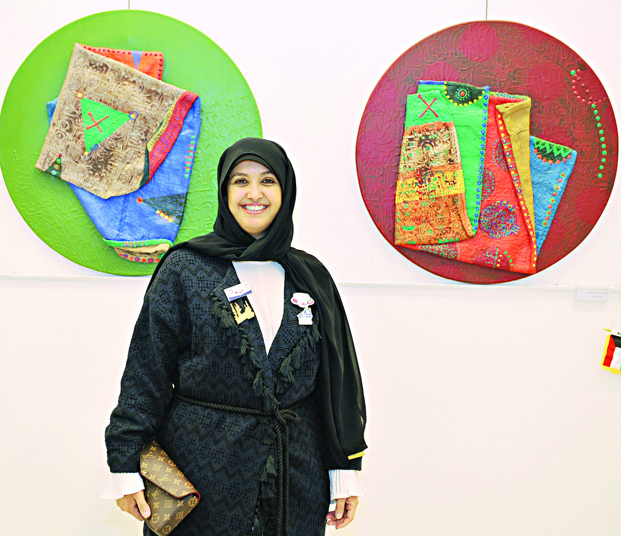 فنانة تشكيلية مع أعمالها