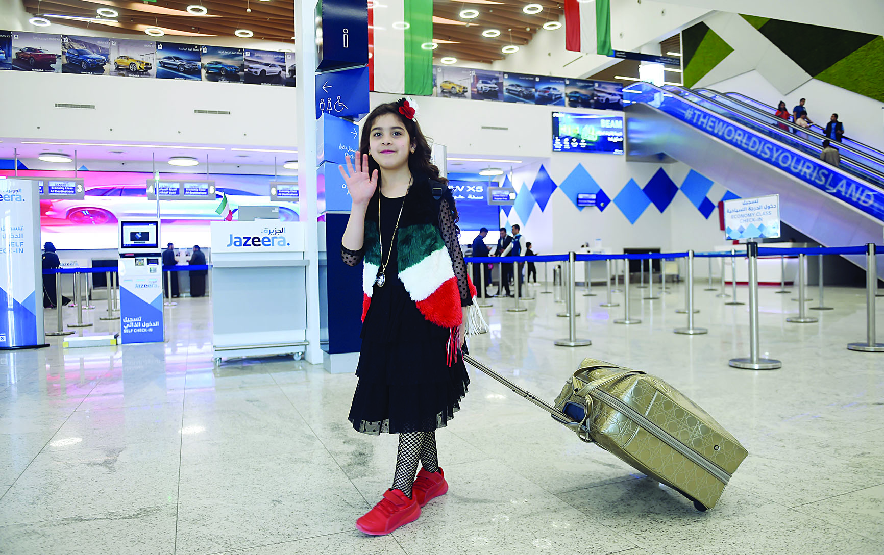 مسافرة بوشاح علم الكويت في مطار الجزيرة