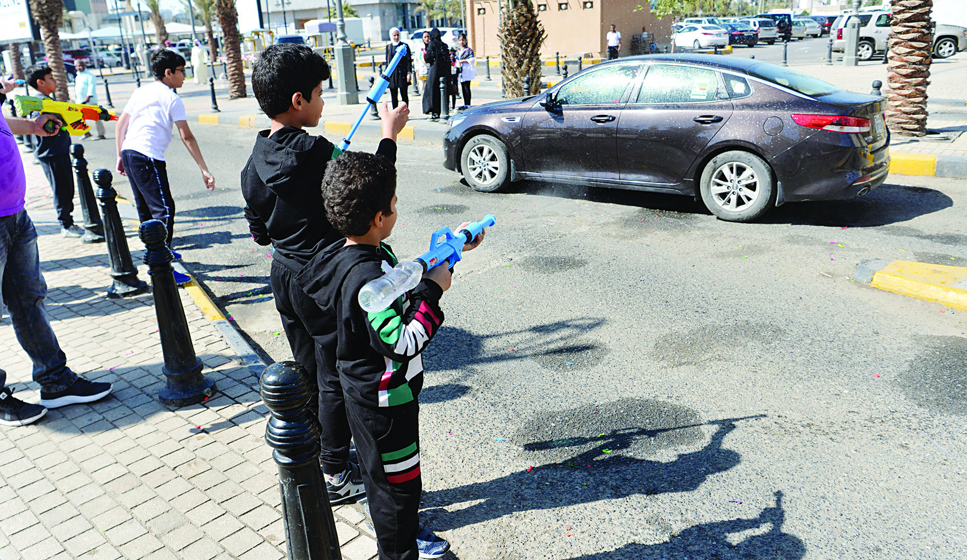 أطفال يترصدون للسيارات بأسلحتهم المائية