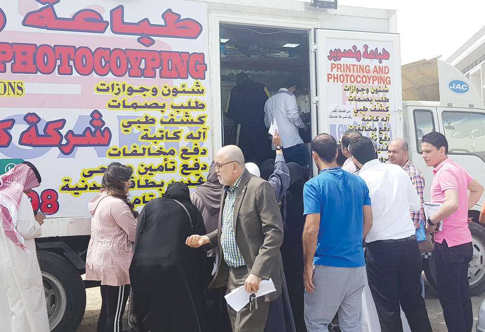 نساء ورجال أمام أحد الكرفانات	 