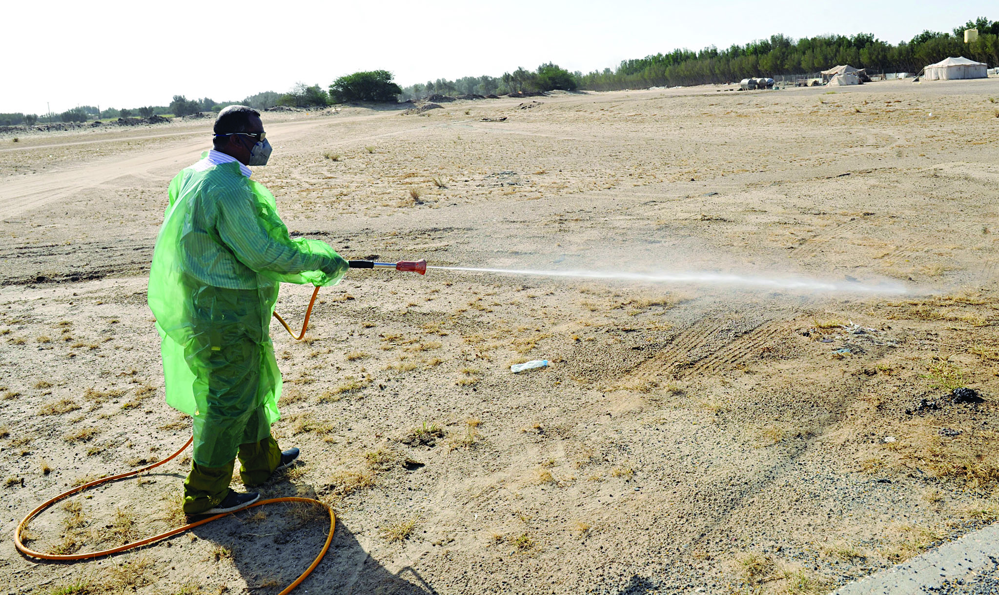 أحد عناصر الفريق يرش المبيدات