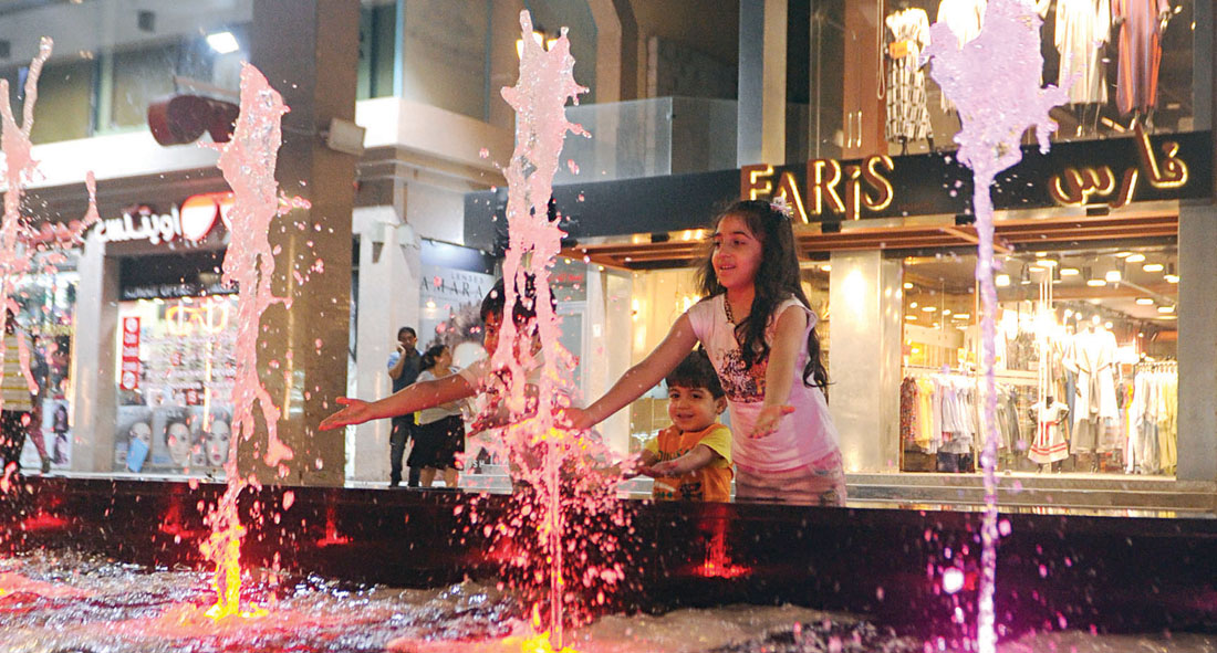 أطفال يلعبون بالنوافير الداخلية لأحد المجمعات 	(تصوير بسام زيدان)