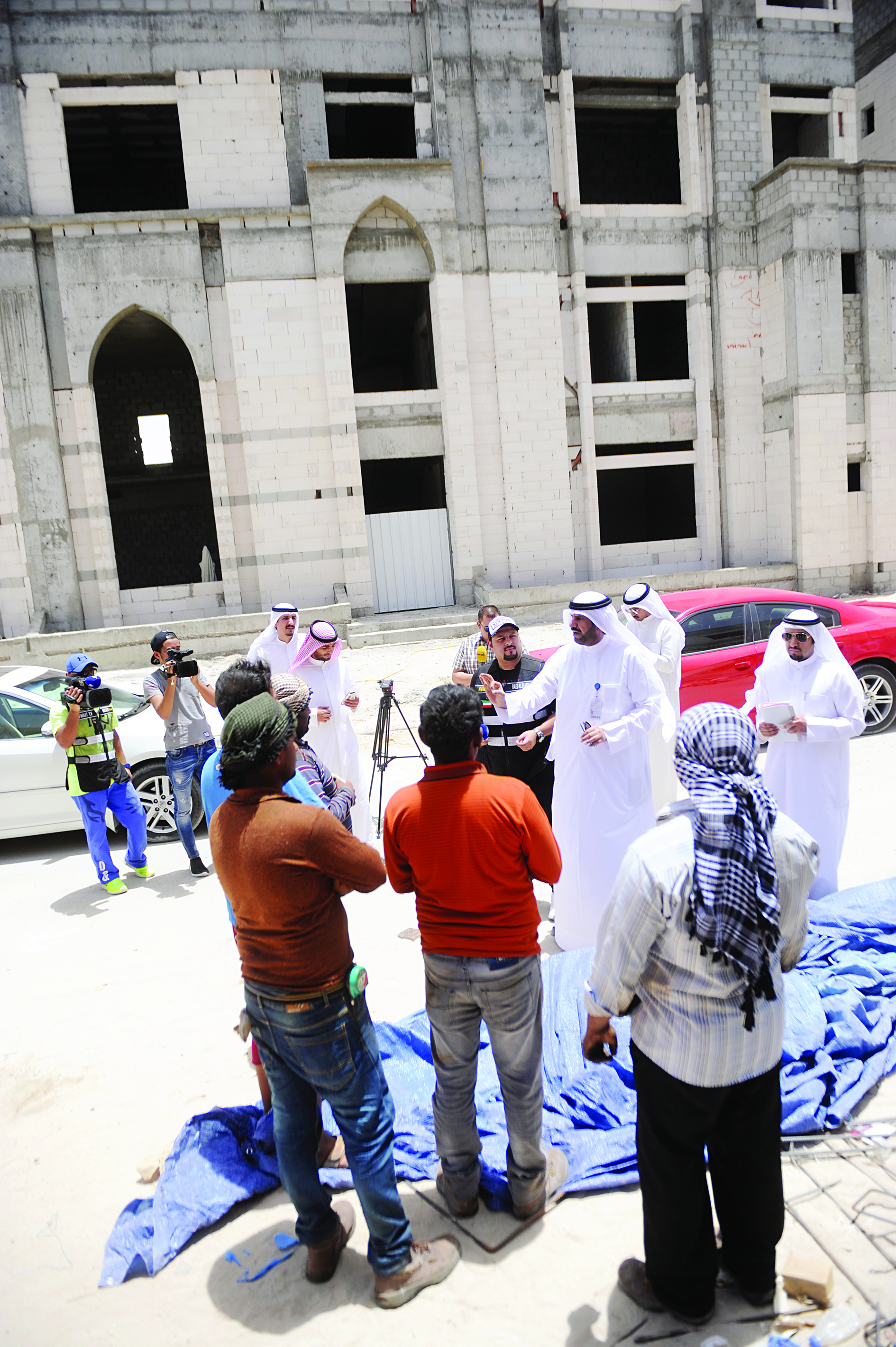 المطيري يتحدث إلى بعض العمال في موقع العمل