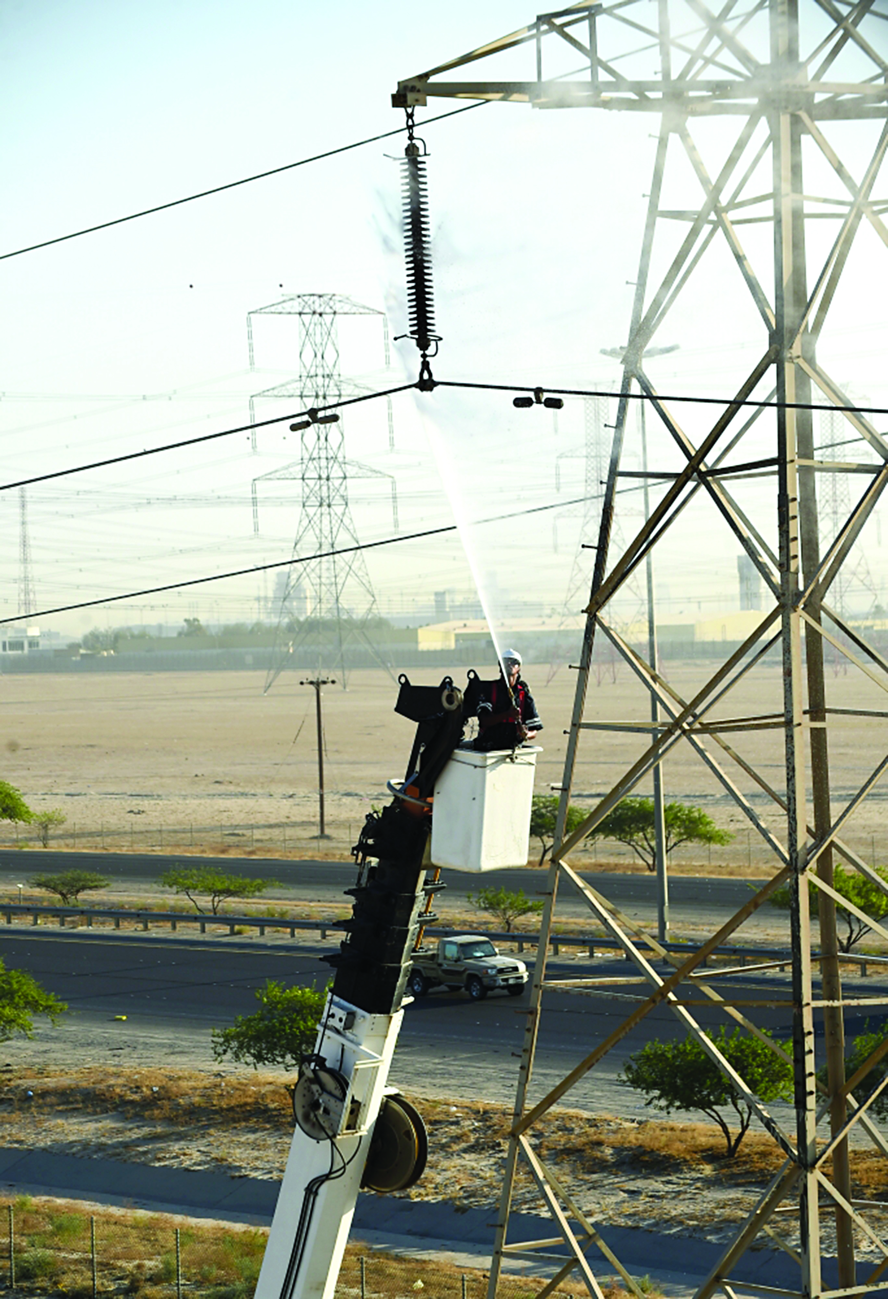 أحد الفنيين يغسل الخط محمولاً على الكرين	 (تصوير أسعد عبدالله)