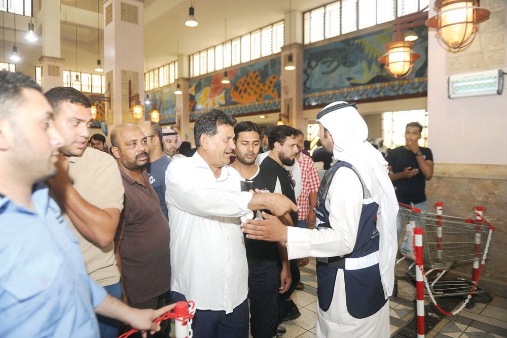 مفتش يتأكد من بطاقات المواطنين لدى الدخول إلى المزاد