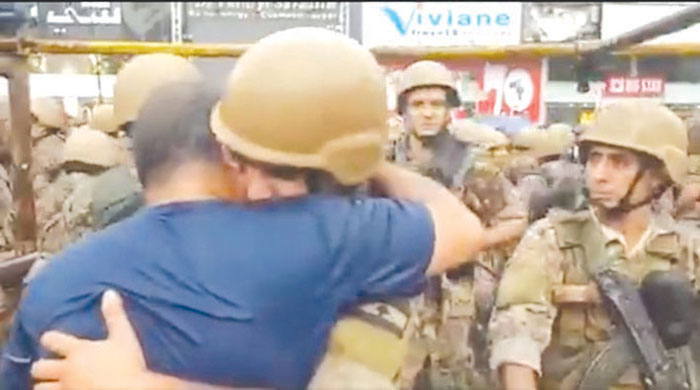 متظاهر يحتضن جندياً يبكي أثناء فتح الطريق في الزوق