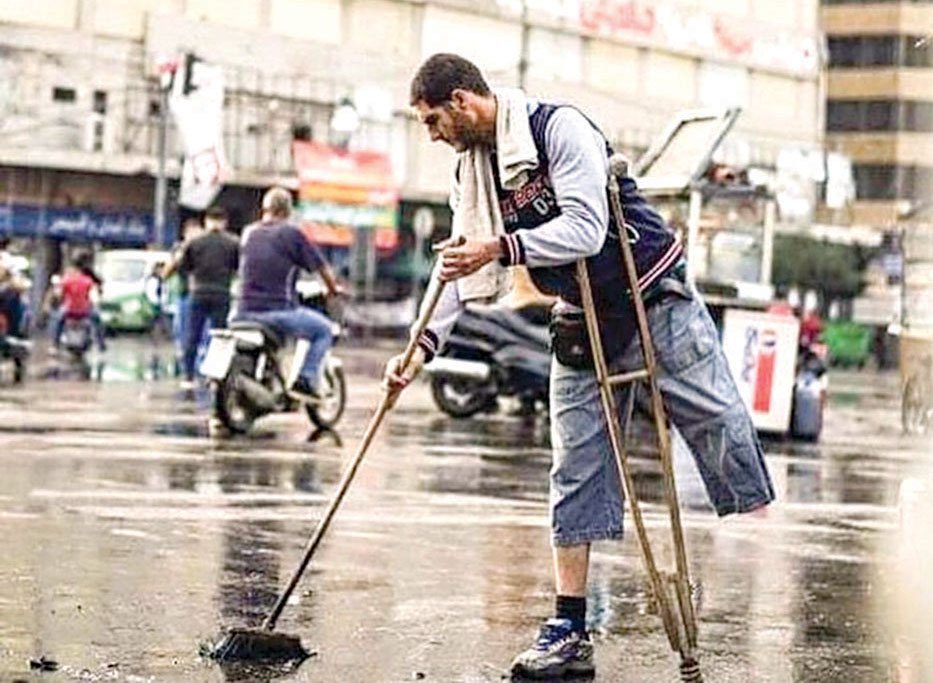 لبناني يقف على قدم واحدة وعكاز يساعد في تنظيف ساحة النور في طرابلس