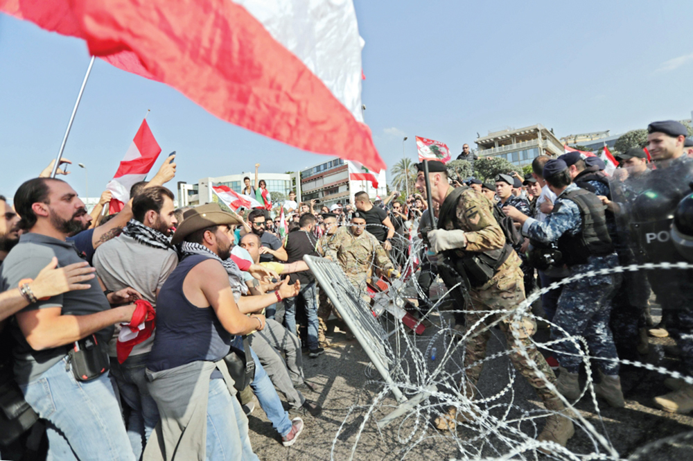متظاهرون في مواجهة القوى الأمنية على طريق القصر الجمهوري أمس	   (أ ف ب)