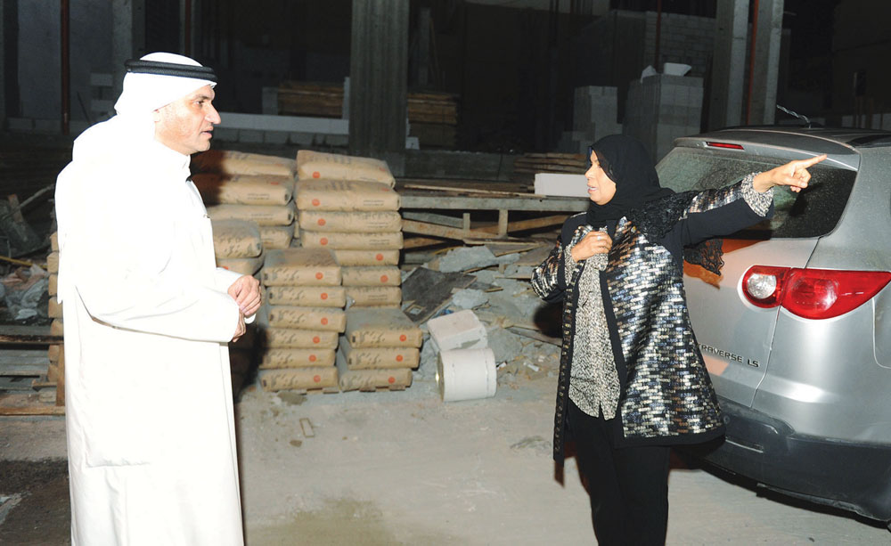 الكندري مستمعاً إلى مواطنة تشير لبيوت العزاب المطلة على منزلها 