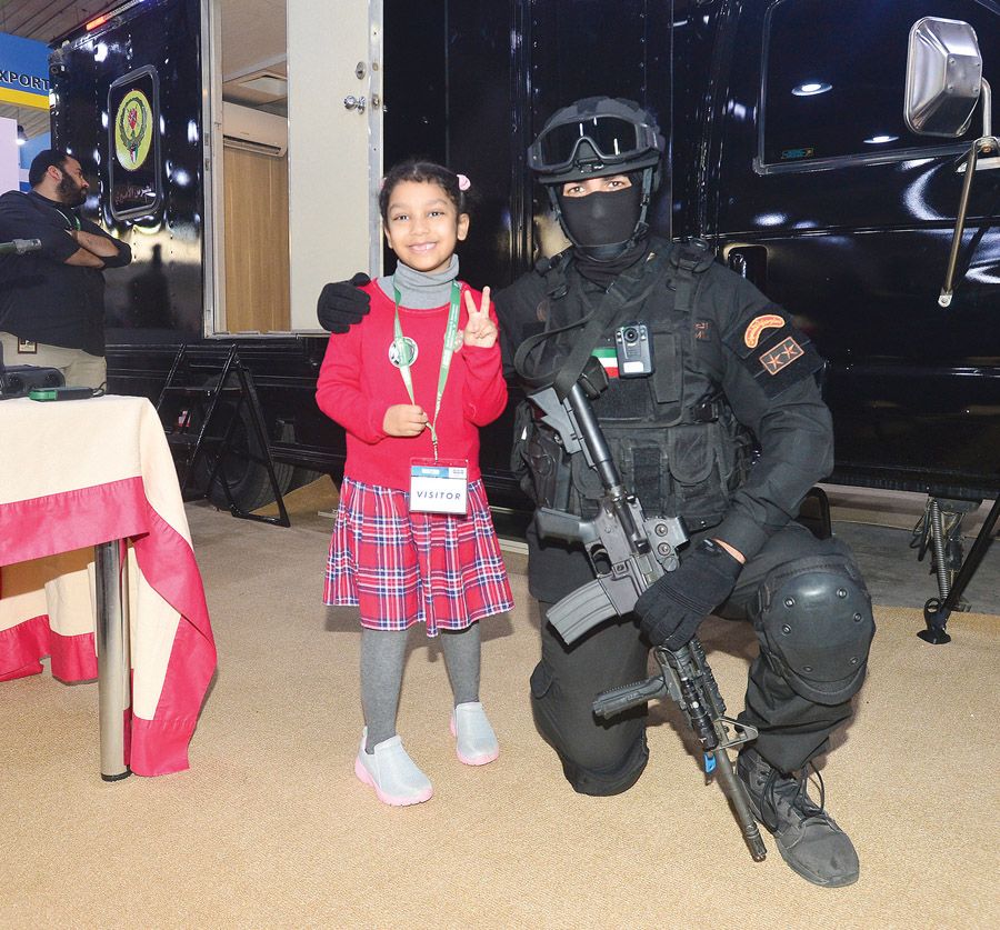 عنصر من الحرس الأميري مع طفلة حضرت المعرض