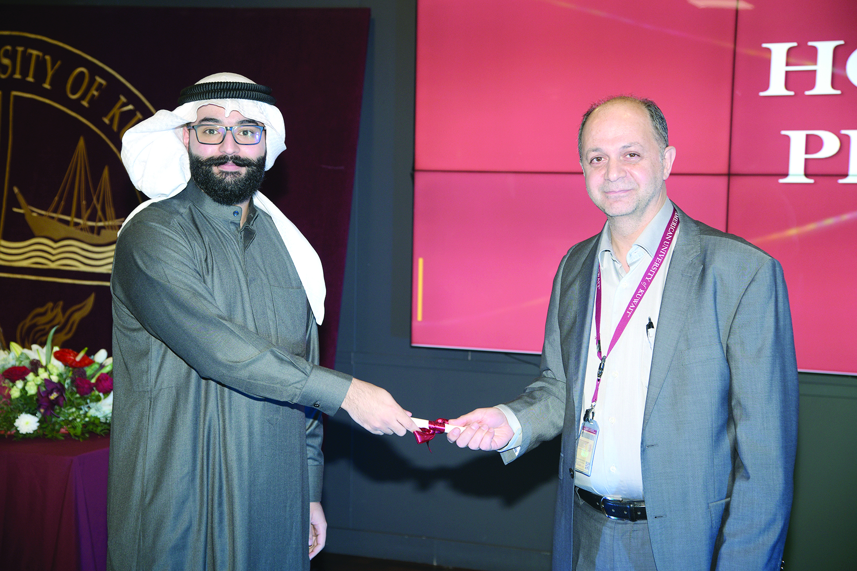 عميد كلية الآداب والعلوم الدكتور علي شرارة يسلم شهادة التفوق لأحد الطلاب